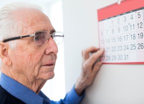 Älterer Mann mit Demenz betrachtet einen Kalender – Symbolbild für Online-Pflegekurs | © PflegeBetreuer | unabhängige Pflegeberatung